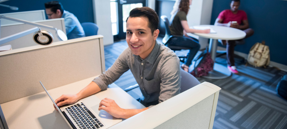 student using laptop on campus