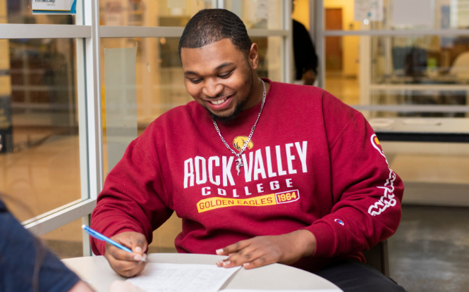 male student wearing red Rock Valley sweater