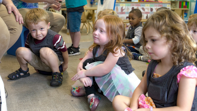 young students sitting in early childhood center