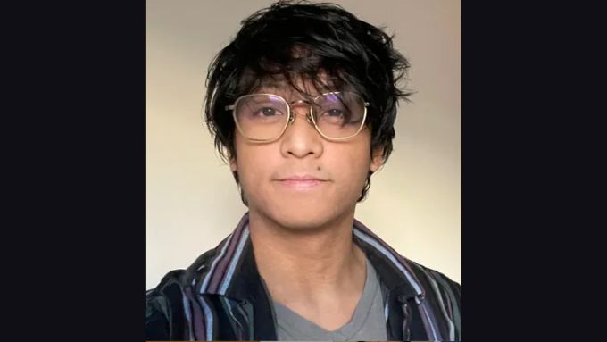 Young Asian man wearing glasses and a black striped shirt