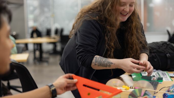 Young female with long red hair in a classroom activity