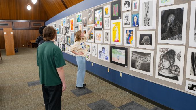 Two caucasian students viewing an art exhibition