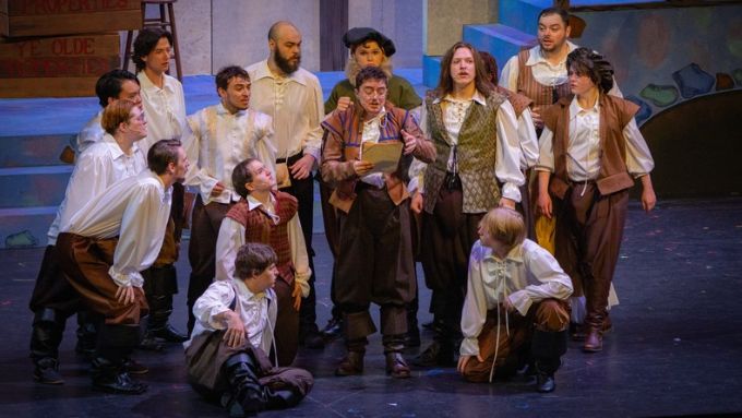 A diverse group of male actors perform a scene