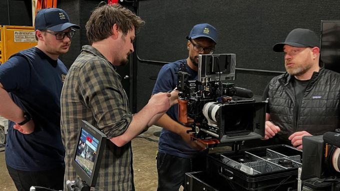 Four students training on a television camera