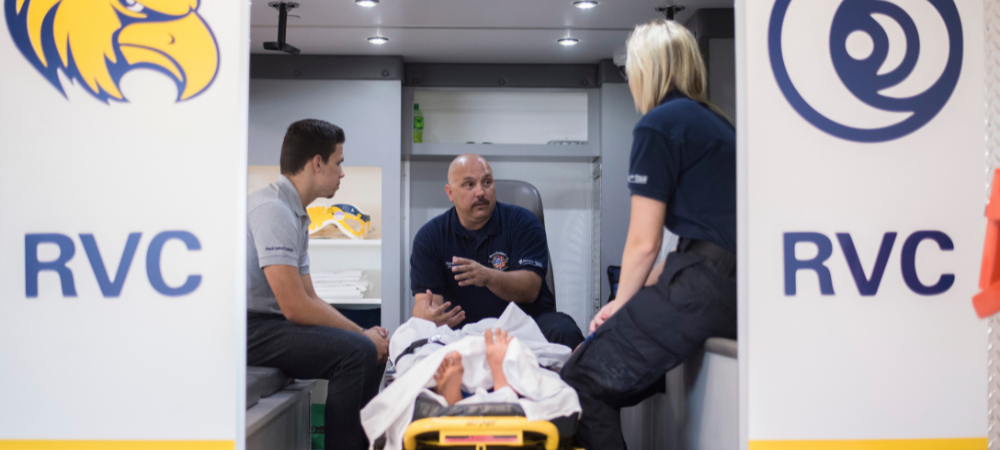 instructor training students inside ambulance setting