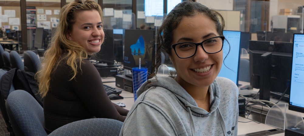 two female students in library computer lab