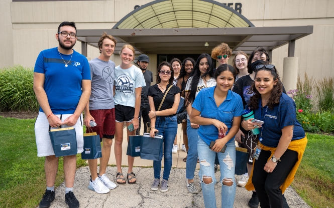 group of new students touring campus with college recruiter